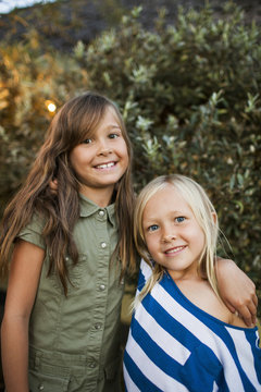 Sweden, Skane, Portrait of two smiling girls (8-9, 10-11) at dusk