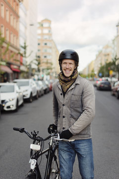 Sweden, Sodermanland, Stockholm, Sodermalm, Hornstull, Mid adult man standing by his bicycle on street