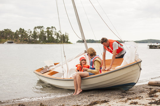 Family sitting in sailboat at seashore