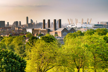 View of Canary Wharf and North Greenwich in east London surrounded by trees from Greenwich Park,...