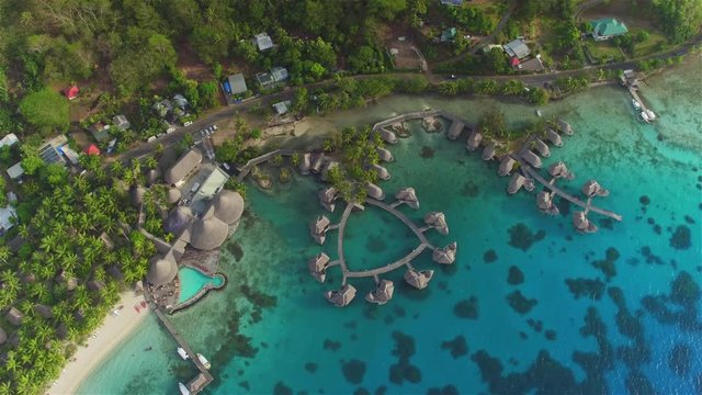 AERIAL: Flying high above luxury hotel resort with overwater villas