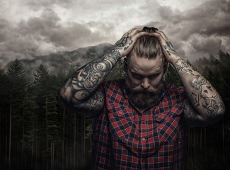 Bearded tattooed male in a red shirt.