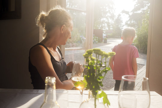 Sweden, Skane, Kullaberg, Mother looking at son (6-7) standing in doorway to backyard at restaurant