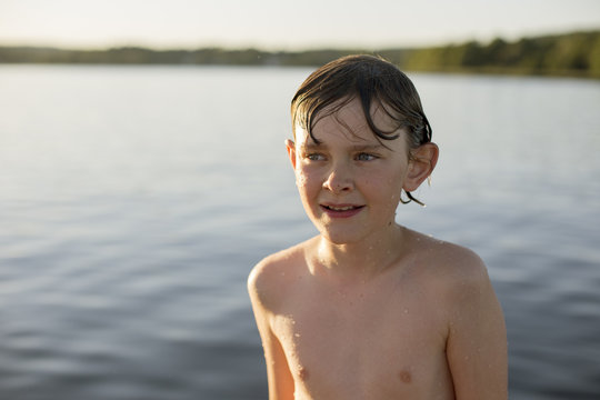 Sweden, Vastergotland, Lerum, Wet boy (12-13) standing by Lake Aspen
