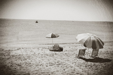 Beach umbrellas and chairs on a beach in Eastham, MA Cape Cod, vintage look.