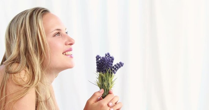 Pretty blonde woman smeling lavender in high quality 4k format
