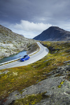 Norway, More og Romsdal, Sunnmore, Geirangerfjord, Blue car driving along winding section of Trollstigen road