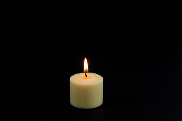 Fototapeta na wymiar candle flame fire of white candle on black background