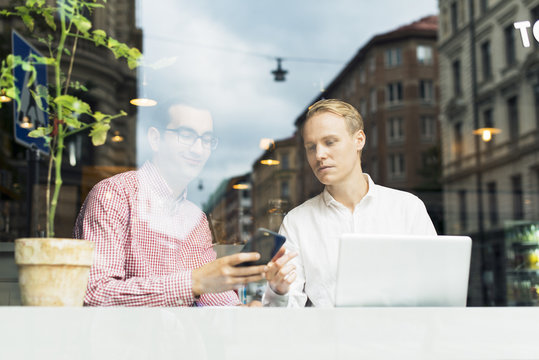 Sweden, Uppland, Stockholm, Two men talking in cafe