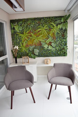 Stylish Sao Paulo Brazil apartment interior with chairs and plant wall, living room