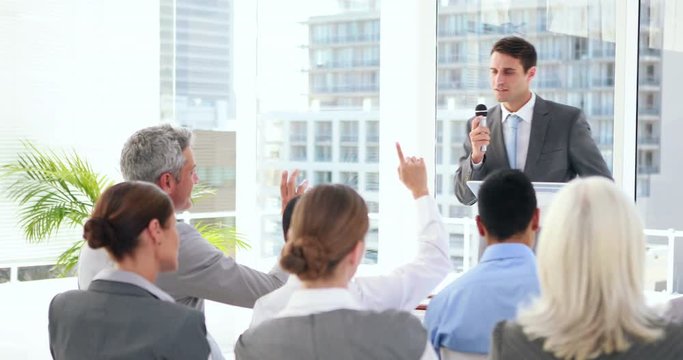 Business people asking question during presentation