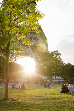 France, Ile-de-France, Paris, People in park by Eiffel Tower at sunset