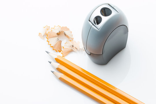 3 pencils and sharpner on white background