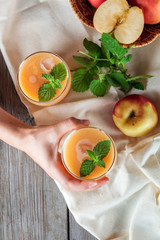 woman's hand holding an apple smoothie