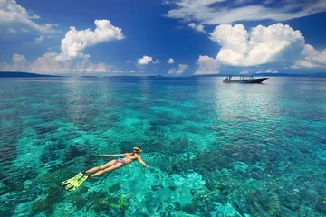 Foto op Canvas Woman snorkeling in clear tropical waters on a background of exo © soft_light