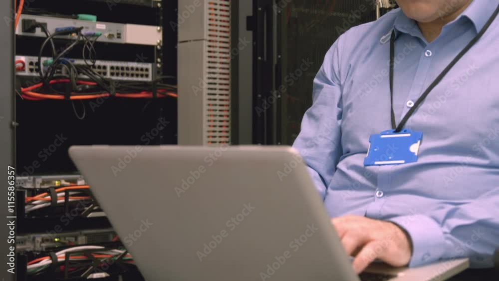 Poster technician using laptop to analyse server