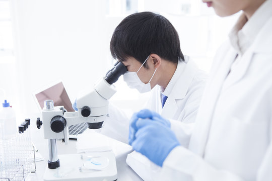 Male researcher looking through a microscope