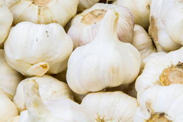 Fresh heads of garlic in a pile at a farmer's market