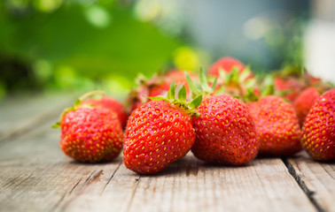 Ripe strawberries on the wooden table. Shallow depth fo field.