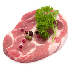 Raw pork neck chop meat with parsley herb leaves and peppercorn