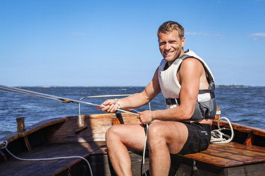 Portrait of smiling young man sitting in boat