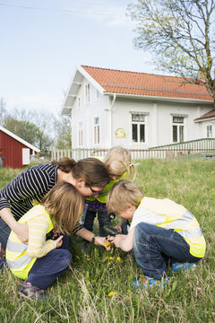 Sweden, Vastergotland, Olofstorp, Bergum, Woman taking care of children (2-3, 4-5, 6-7) outdoors