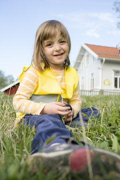Sweden, Vastergotland, Olofstorp, Bergum, Portrait of girl (4-5) sitting in grass