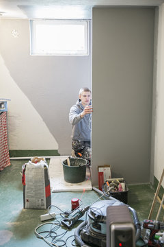 Young man tiling wall