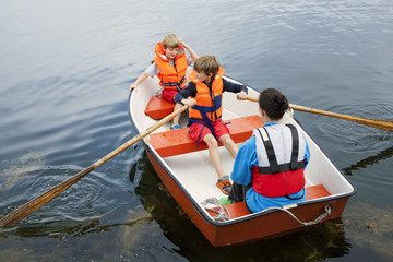 Sweden, Uppland, Runmaro, Barrskar, Woman with two boys in rowboat