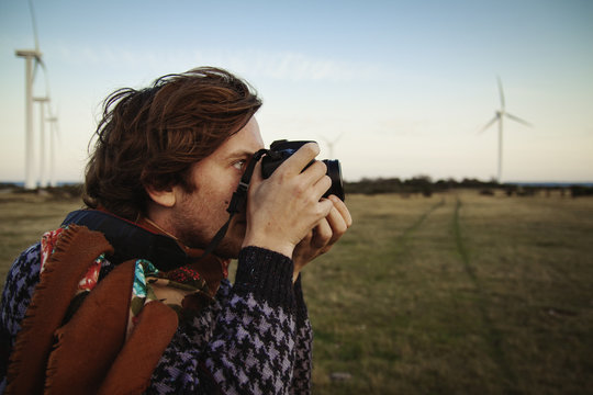 Sweden, Gotland, Nas socken, Young man photographing field