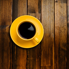 yellow cup coffee on wood background