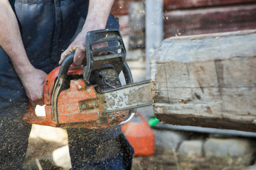 Finland, Close-up of man cutting log with chainsaw