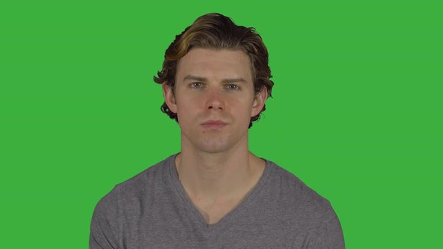 Young guy turns to camera with serious look (Green Key)
