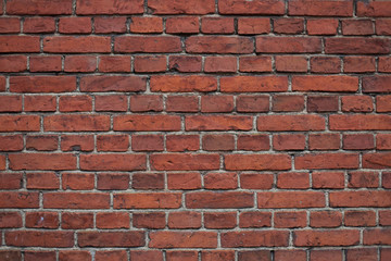 Aged, cracked, dark red brick wall background
