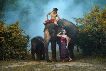 Fototapeta na wymiar Thai woman ,man and Young elephant in Thai culture traditional ,vintage style