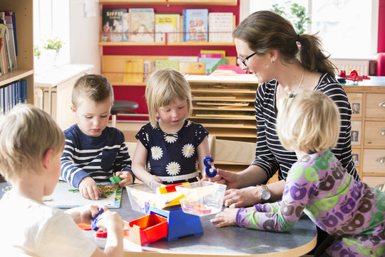 Sweden, Children playing with teacher in kindergarten