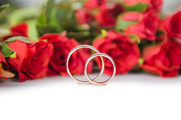 Wedding rings and flowers isolated on white background