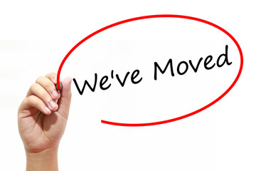 Man Hand writing We've Moved with marker on transparent wipe board. Business, internet, technology concept.