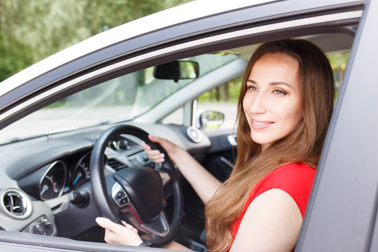 Young beautiful woman steering wheel driving a car