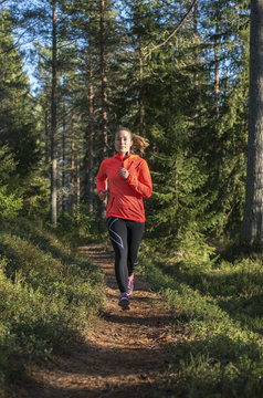 Finland, Pohjanmaa, Pietarsaari, Faboda, Young woman jogging in forest