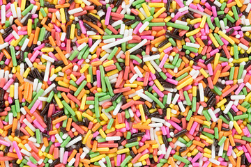 Fototapeta na wymiar Colorful candy sprinkles background. Top view