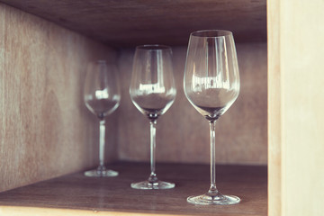 empty wine glasses set on shelf at restaurant