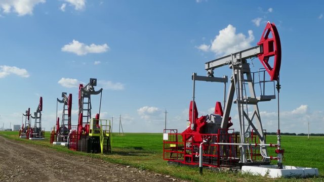 working oil pumps in a row at sunny day, 4k
