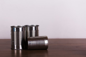 Battered tin cans on a wooden background