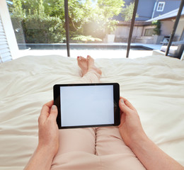 Woman using a digital tablet on the bed
