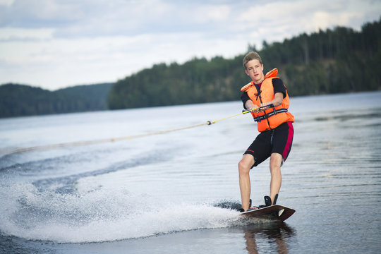 Boy wakeboarding in lake