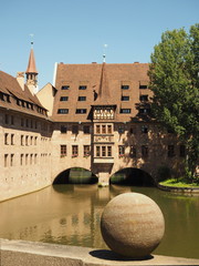 Nuremberg, Germany - June 23, 2016: Hospice of the Holy Spirit and old houses with the Pegnitz river