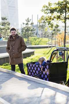 Sweden, Skane, Malmo, Father driving son (6-7) in urban park