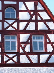 Gable and façade details of an old timber frame medieval house with white render and red beams in Nuermberg 2016