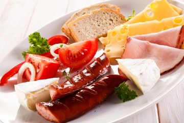 Breakfast - fried sausages, yellow cheese and vegetables 